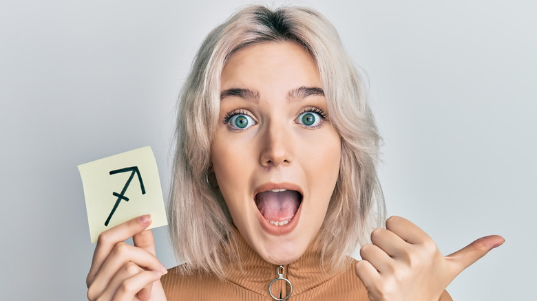 woman holding Sagittarius symbol