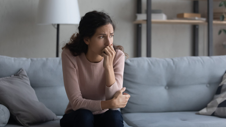 Worried woman on couch