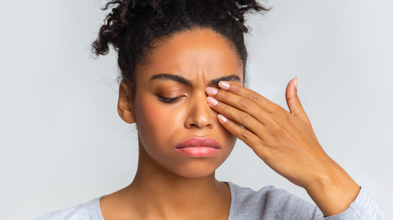 Woman covering eye infection