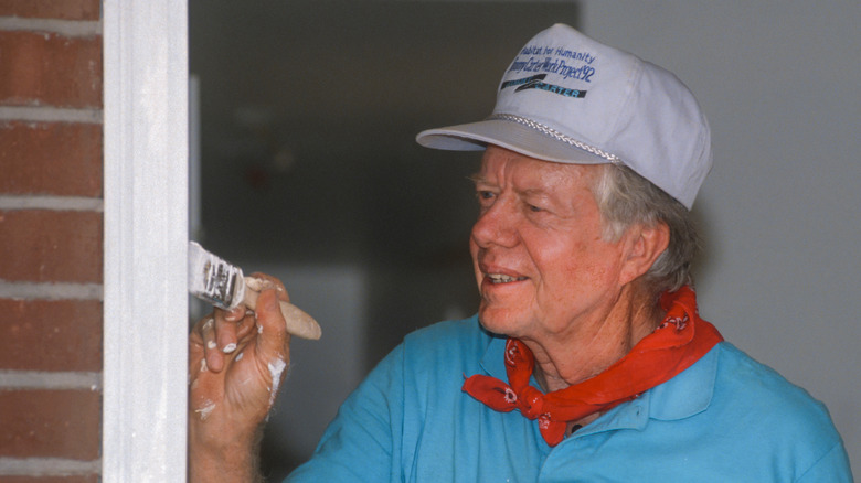 Former President Jimmy Carter painting a door