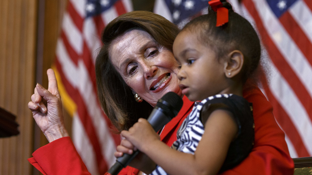 Nancy Pelosi holding a young girl