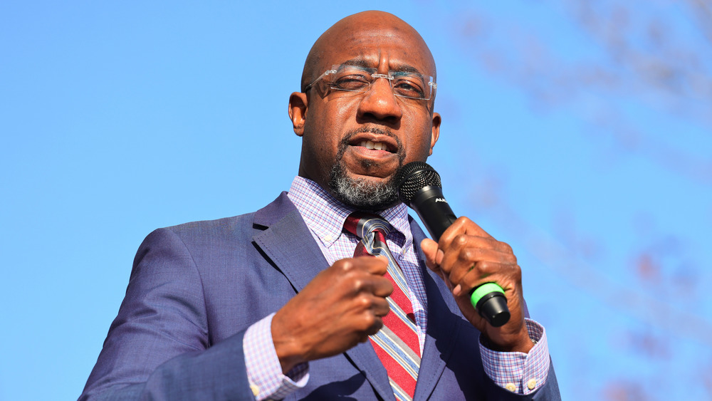 Raphael Warnock campaigning in red and blue striped tie