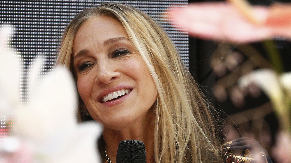 Sarah Jessica Parker smiling, holding mic