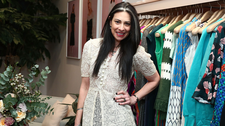 Stacy London posing by clothing