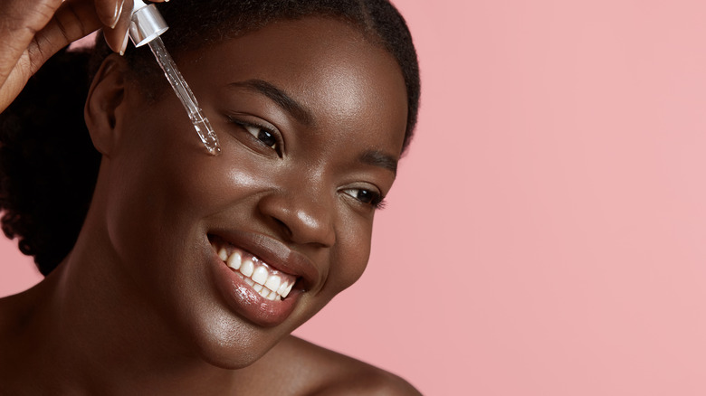 Woman applying face serum