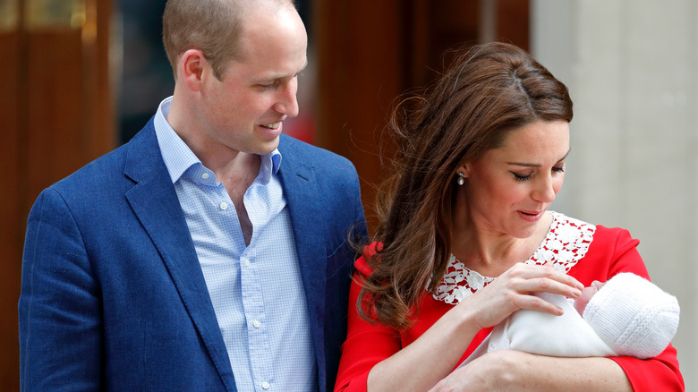 Prince William and Princess Catherine smiling at their newborn