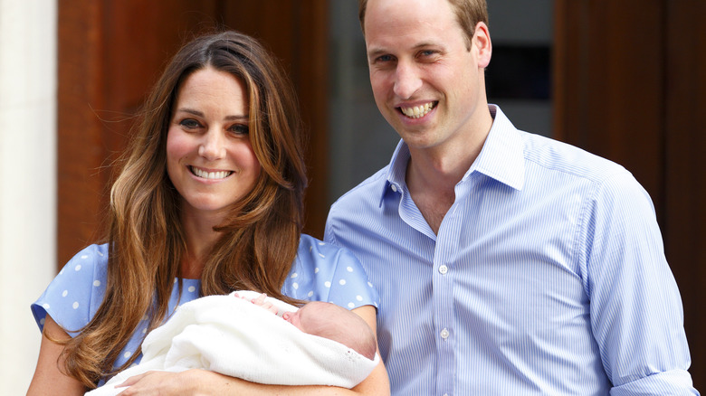 Prince William and Princess Catherine smiling with baby George