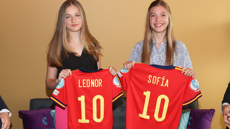 Princess Leonor and Infanta Sofia hold soccer jerseys with their names