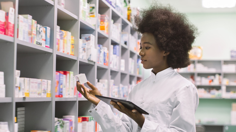 A pharmacy tech reading a pill box