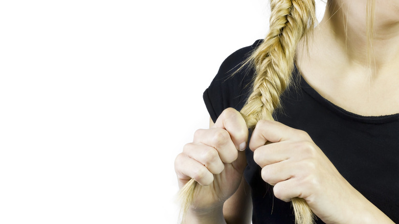 Woman holding the two hair sections of a fishtail braid