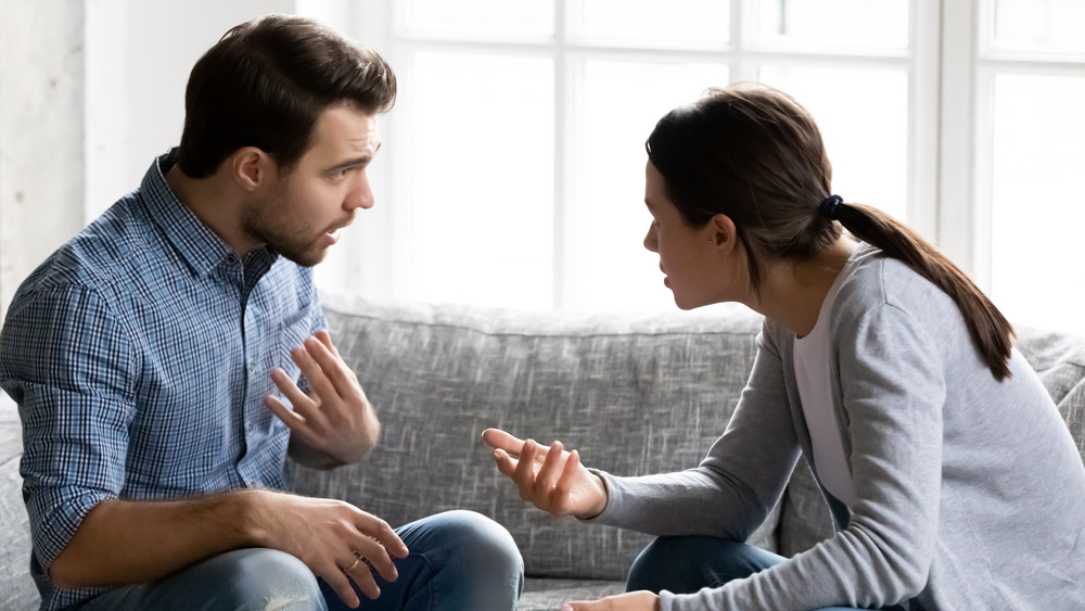 couple having a noticeable disagreement while sitting on a couch 