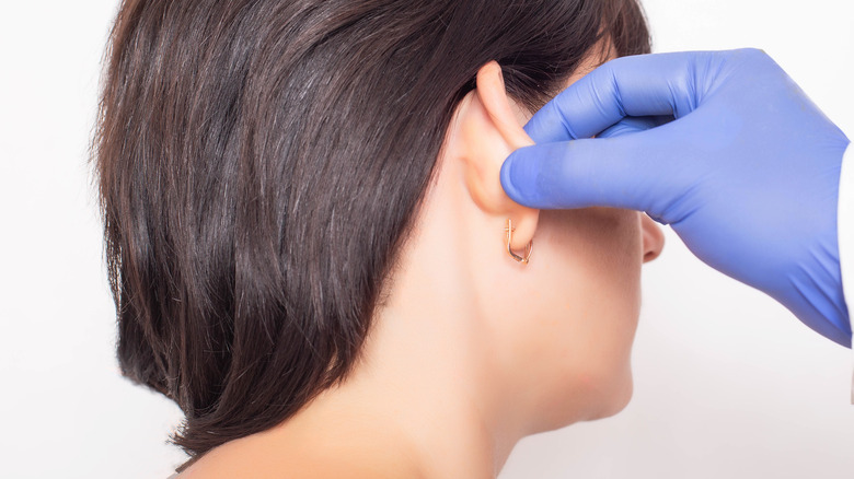 Surgeon examining woman's ear