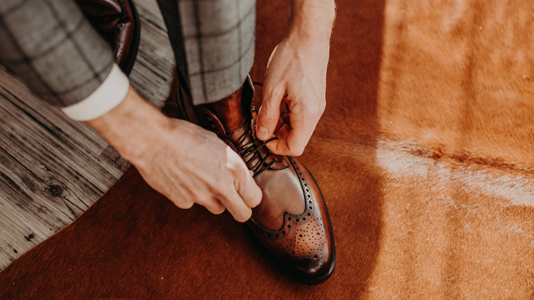 Man tying brown shoes