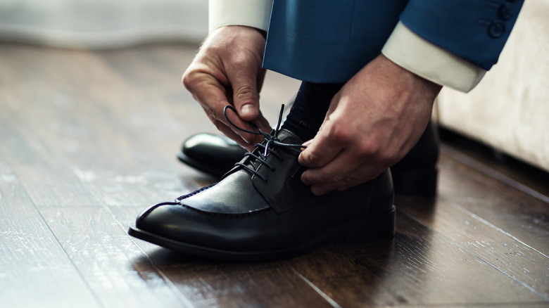 Man tying black shoes