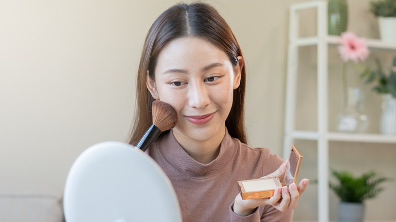 woman applying powdered sunscreen