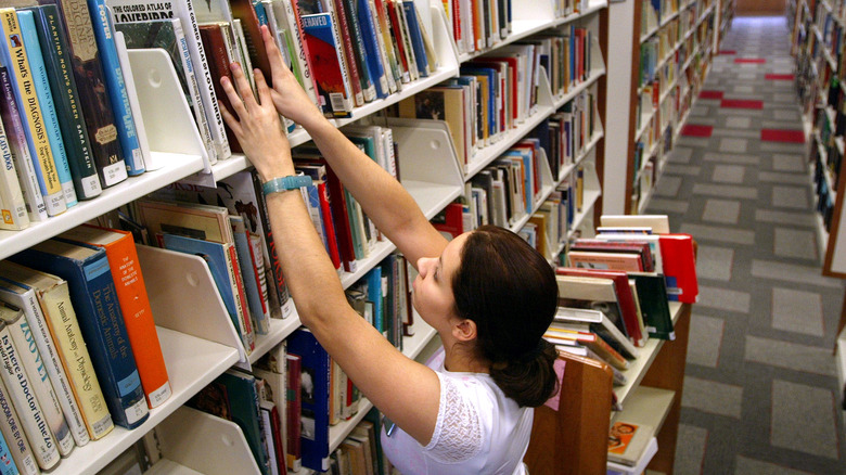 Librarian stacking books