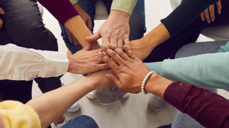 Team of employees joining hands