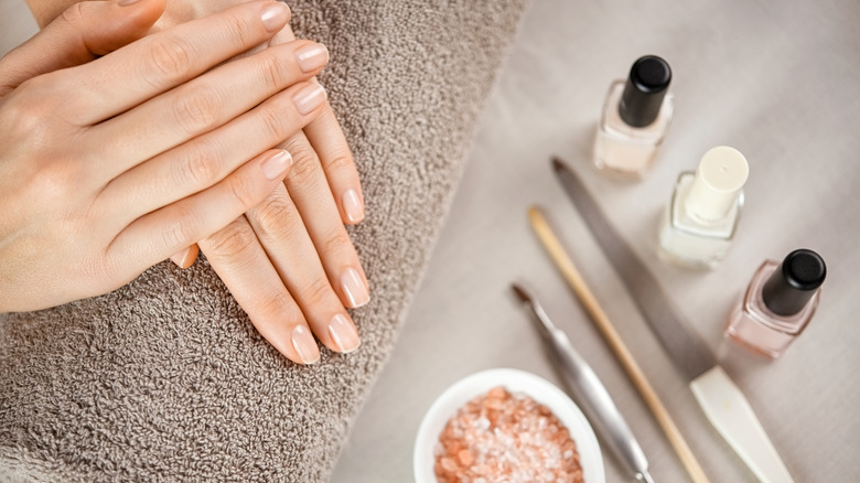 Hands with nail files and nail polishes