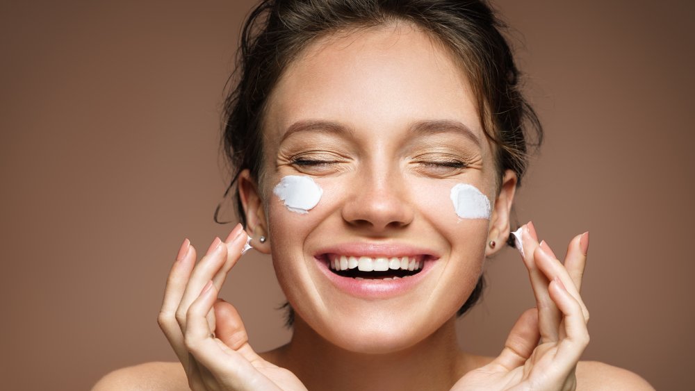 Woman applying moisturizer