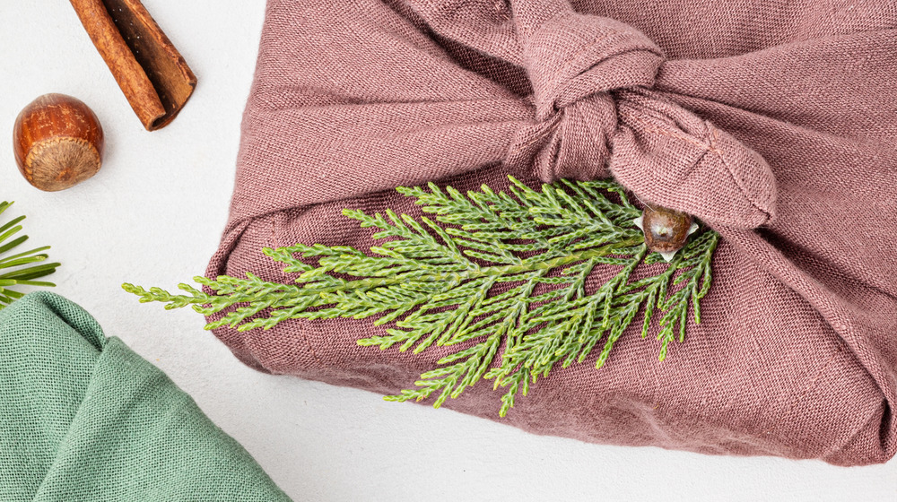 Furoshiki cloth wrapped gift with winter greenery