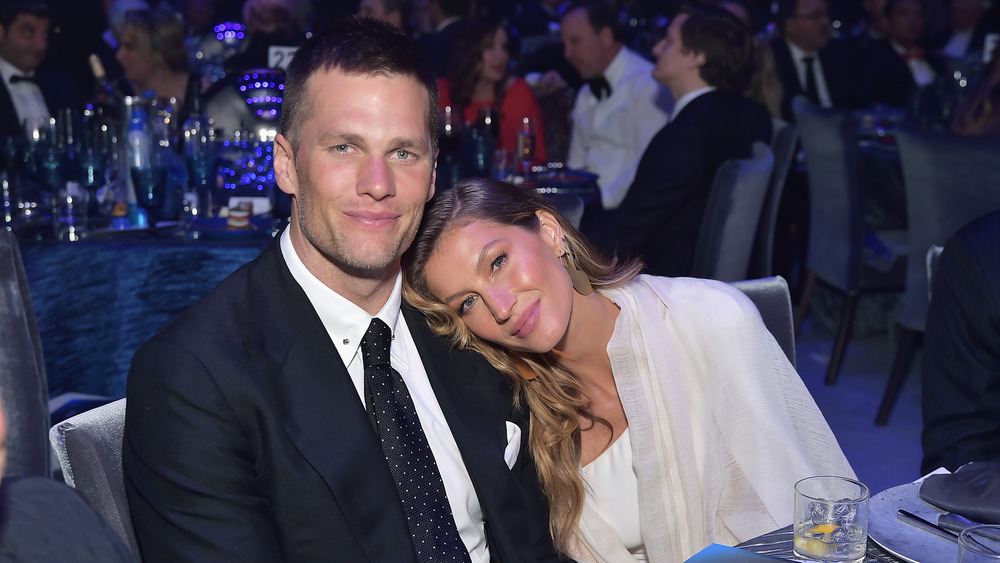 Tom Brady and Gisele Bundchen sitting at dinner table