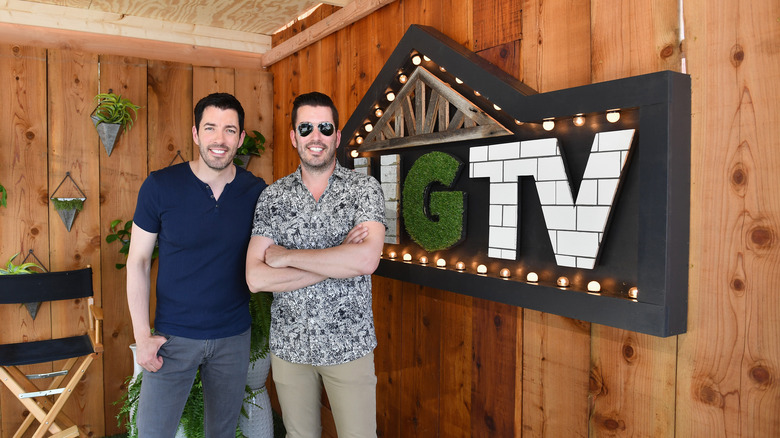 The Property Brothers in front of an HGTV sign