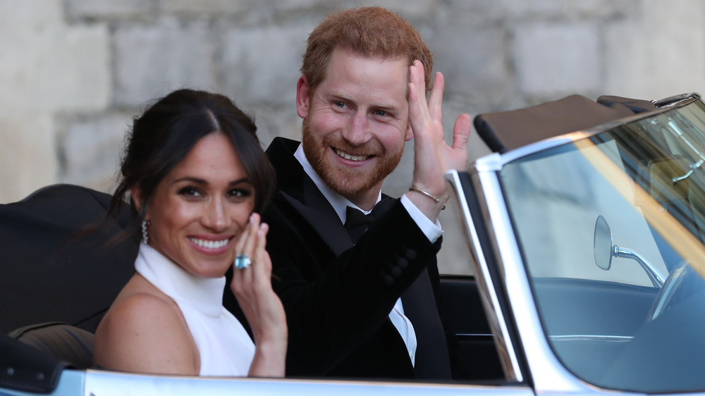 Prince Harry and Meghan Markle waving in car