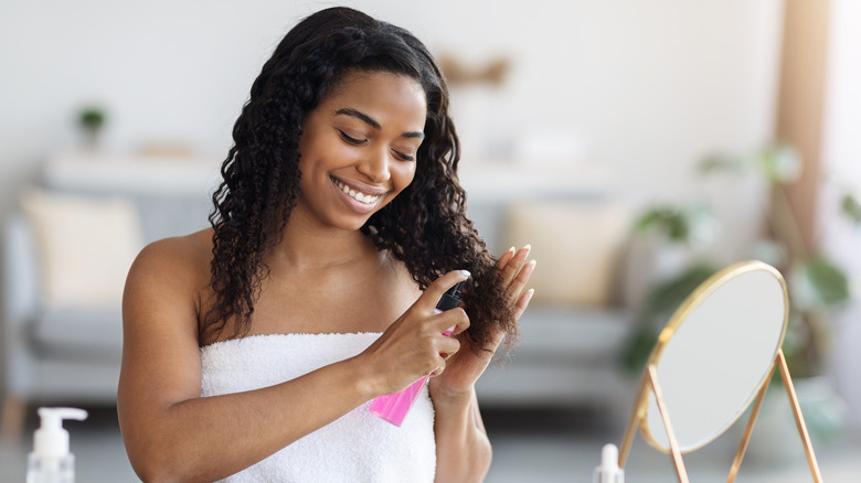 Woman moisturizing her curly hair