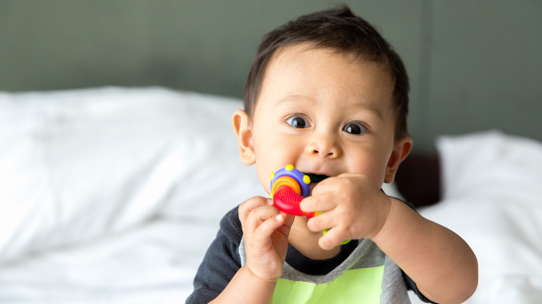 baby chewing on toy