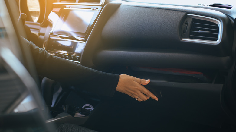 woman opening glove compartment