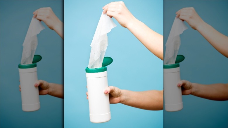 pulling disinfecting wipes from container