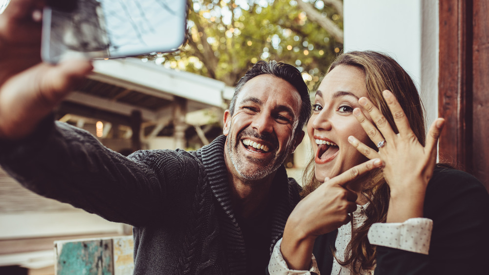 Couple showing off engagement ring