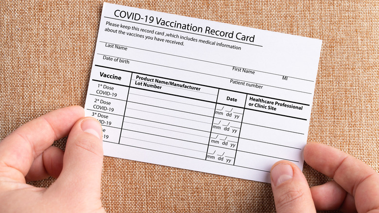 Person holding COVID-19 vaccination card