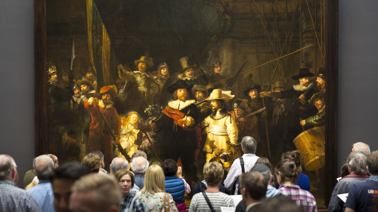 Tourists view The Night Watch by Rembrandt 