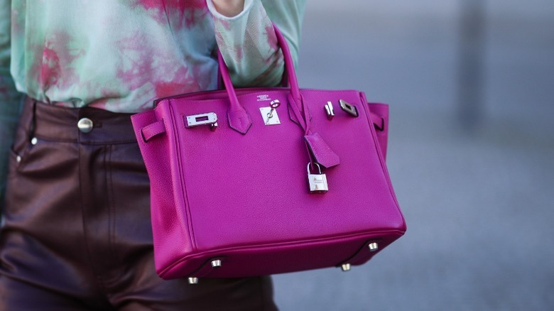 Woman carrying fuchsia Hermes Birkin bag