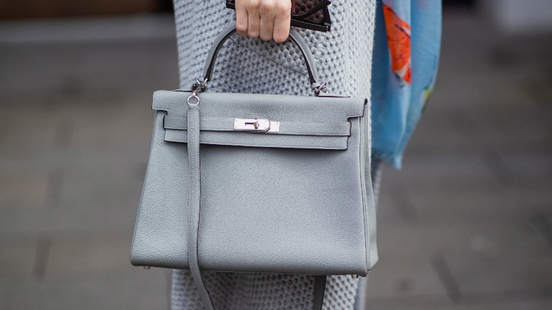 Woman carrying gray Hermes Kelly bag 