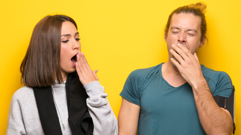 Two people yawning 