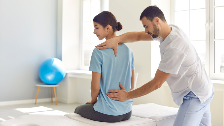 A chiropractor adjusts posture