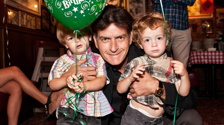 Charlie Sheen smiling alongside twin sons as toddlers