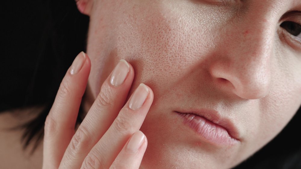 A woman inspecting her skin 