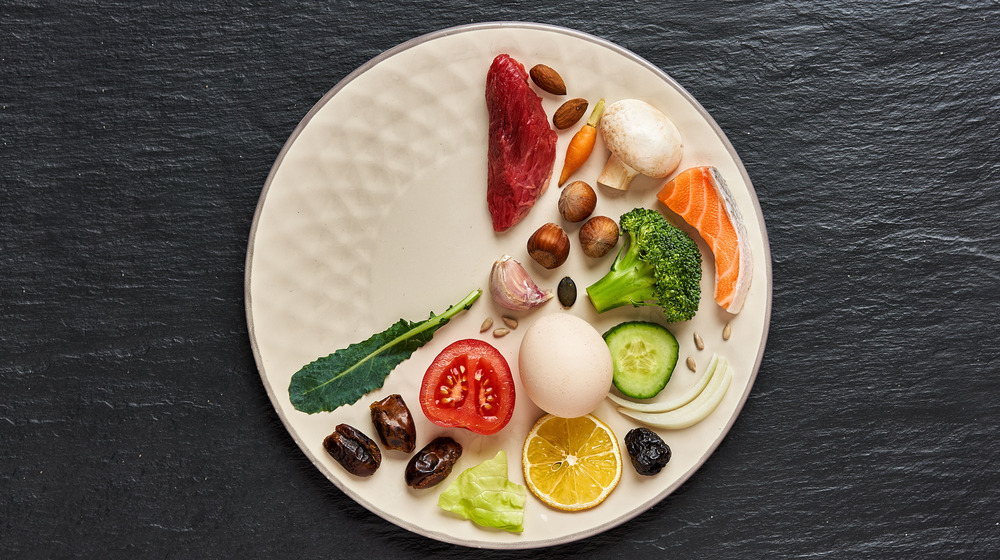Colorful food arranged on a plate like it's a clock