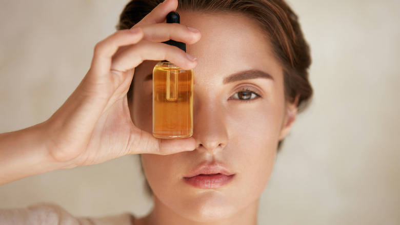 Woman holding essential oil bottle