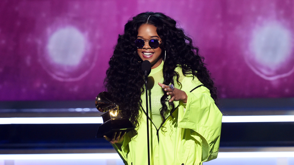 H.E.R. accepting an award wearing sunglasses