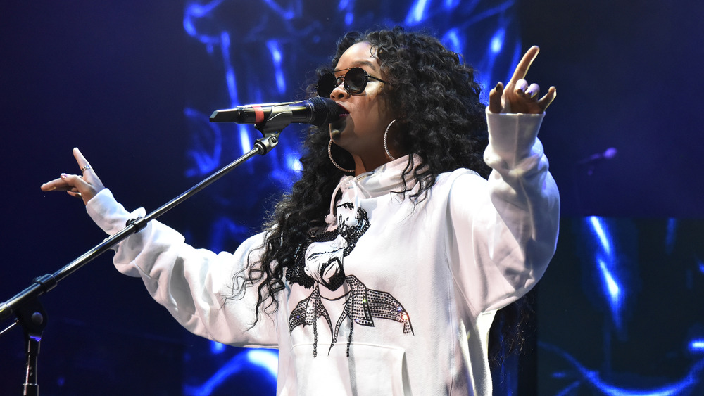 H.E.R. on stage wearing dark sunglasses