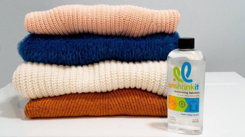 Unshrinkit bottle next to folded sweaters