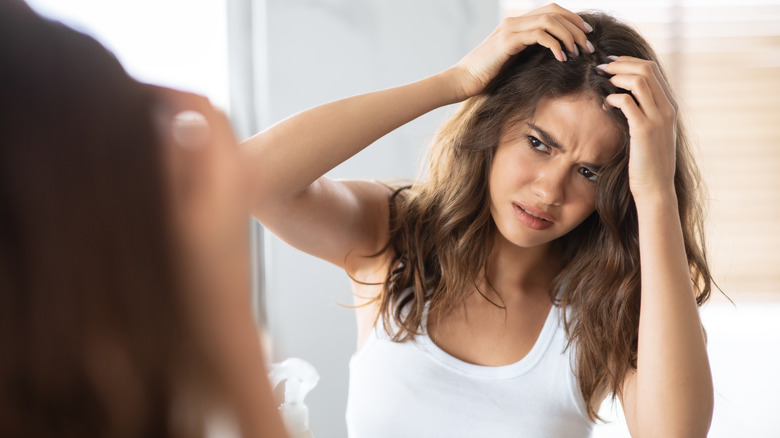 woman checking hair in mirror