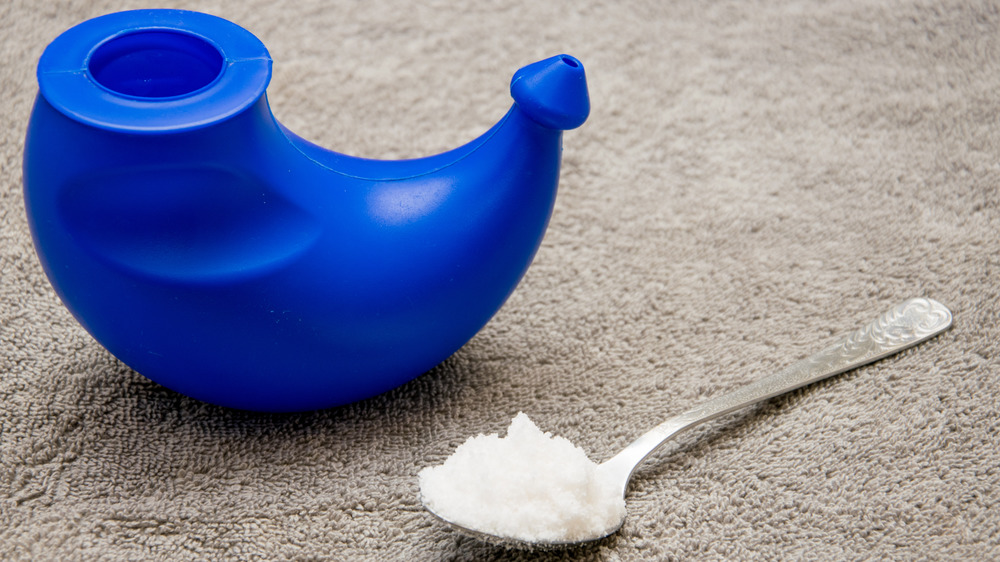 Blue Neti pot next to a spoon of salt