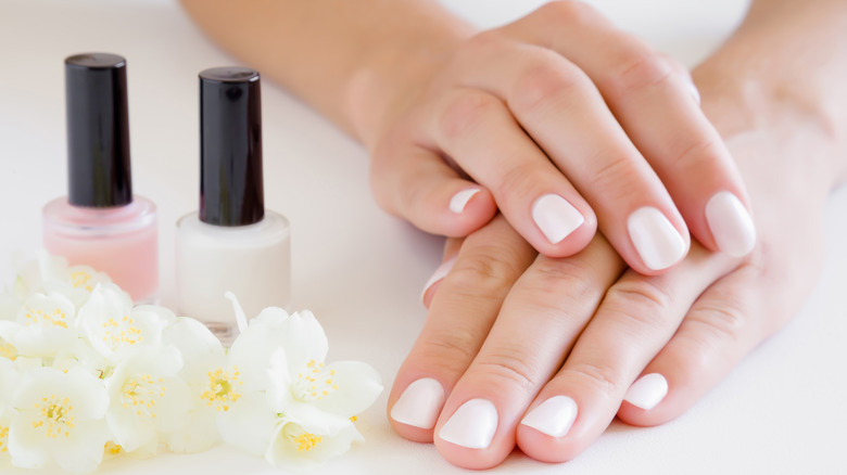 Neutral nail manicure with nail polish and flowers