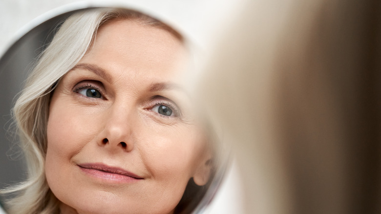 Woman seeing her reflection in mirror