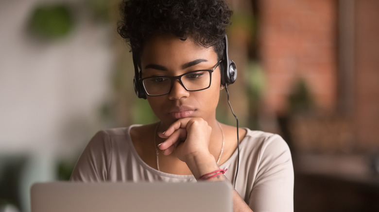 Woman thinking, wearing headphones